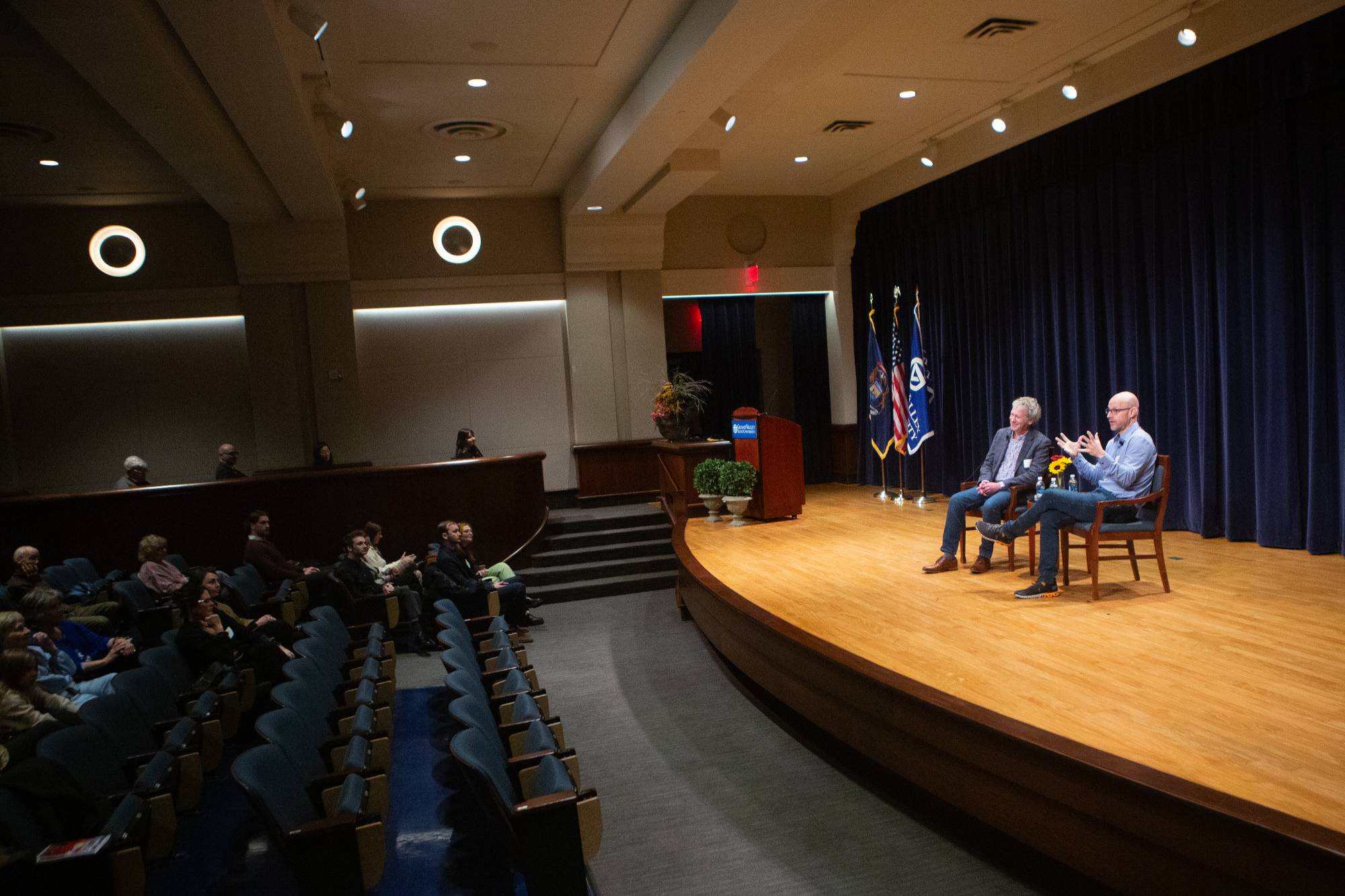 two people sitting on stage